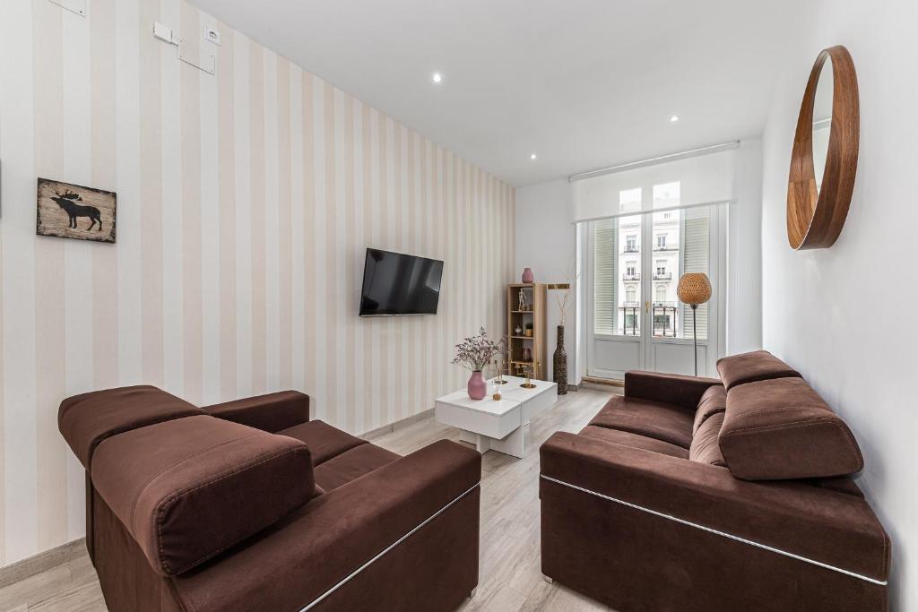 马德里BNBHolder Apartamentos en Sol Confort 9的客厅配有2张棕色沙发和电视