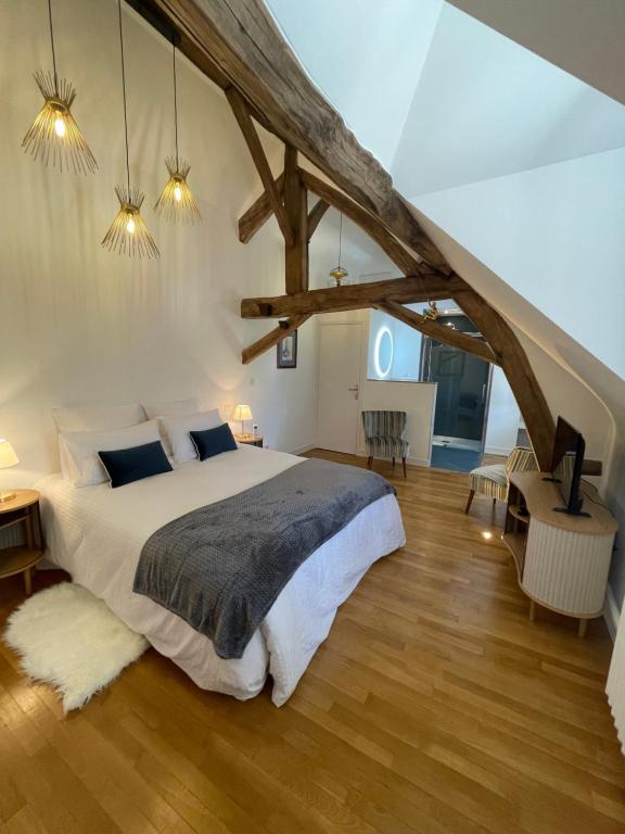 Cléry-Saint-AndréLe Clos du Q’hâtre的一间卧室设有一张大床,铺有木地板。