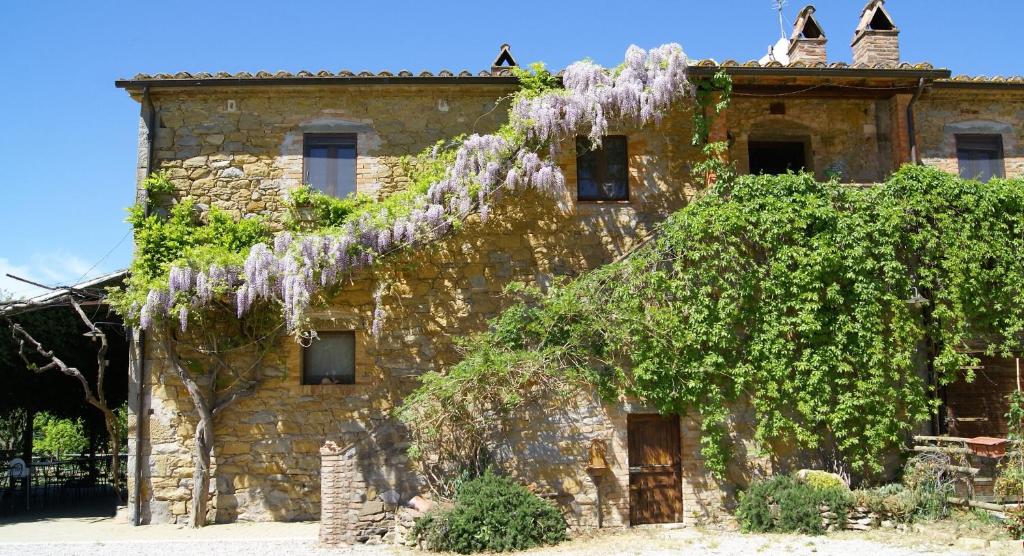 马焦内卡萨迪坎帕格纳酒店的一座古老的石头建筑,上面有紫藤