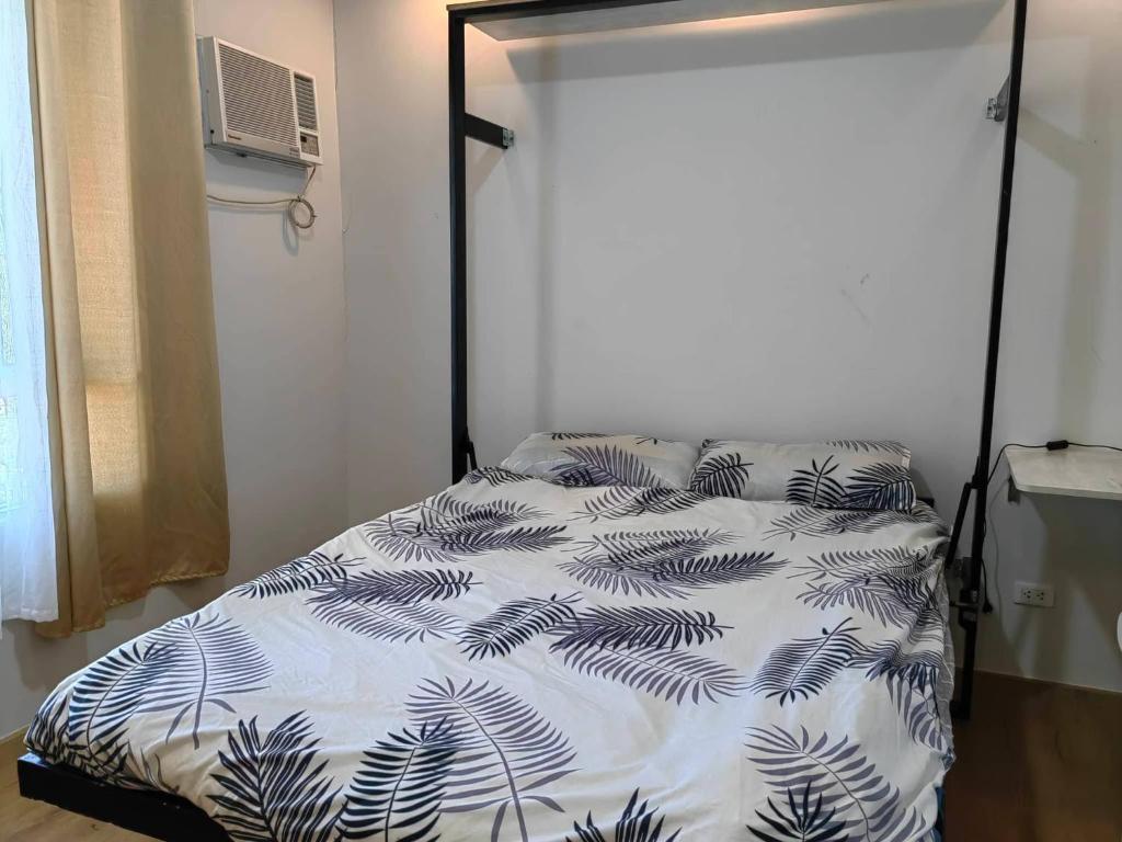 达沃市Mesatierra Garden Residences - Condo的卧室配有一张带白色和黑色棉被的床