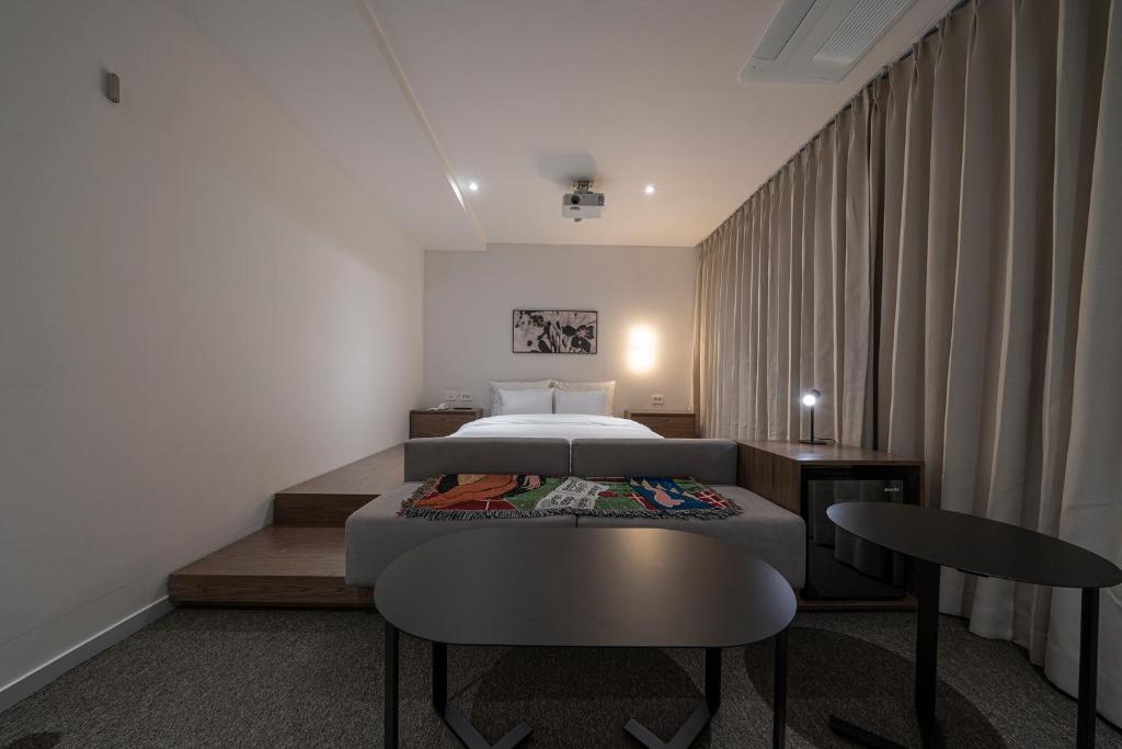 乌山市Aank Hotel Osan的卧室配有一张床和一张桌子及椅子
