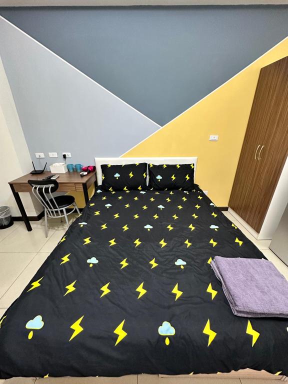 Chia-hsiu週週客棧的一间卧室配有一张黄色星光的黑色床