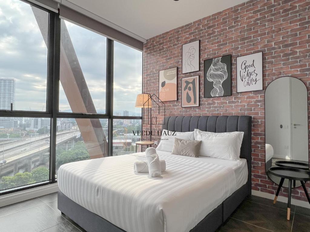 吉隆坡Scarletz Suites at KLCC by Veedu Hauz的一间卧室设有一张带砖墙的大床