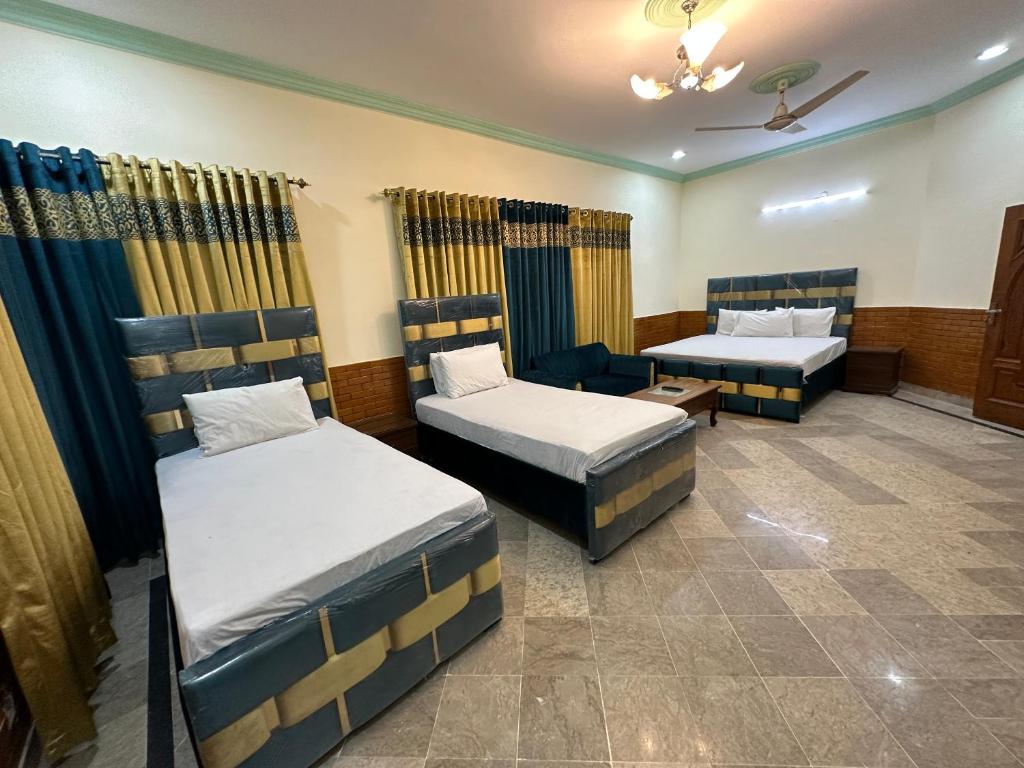 伊斯兰堡Decent Lodge Guest House F-11的一间客房配有两张床和一张沙发