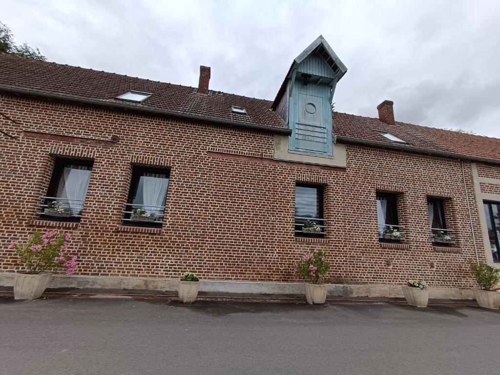 CappyGîte chez Julie et Franck的砖砌的建筑,旁边是钟