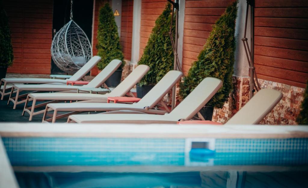 巴库里阿尼Hotel Sapphire Bakuriani的游泳池旁的一排躺椅