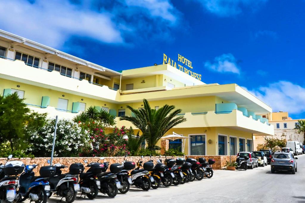兰佩杜萨Hotel Baia Turchese的停在酒店前面的一排摩托车