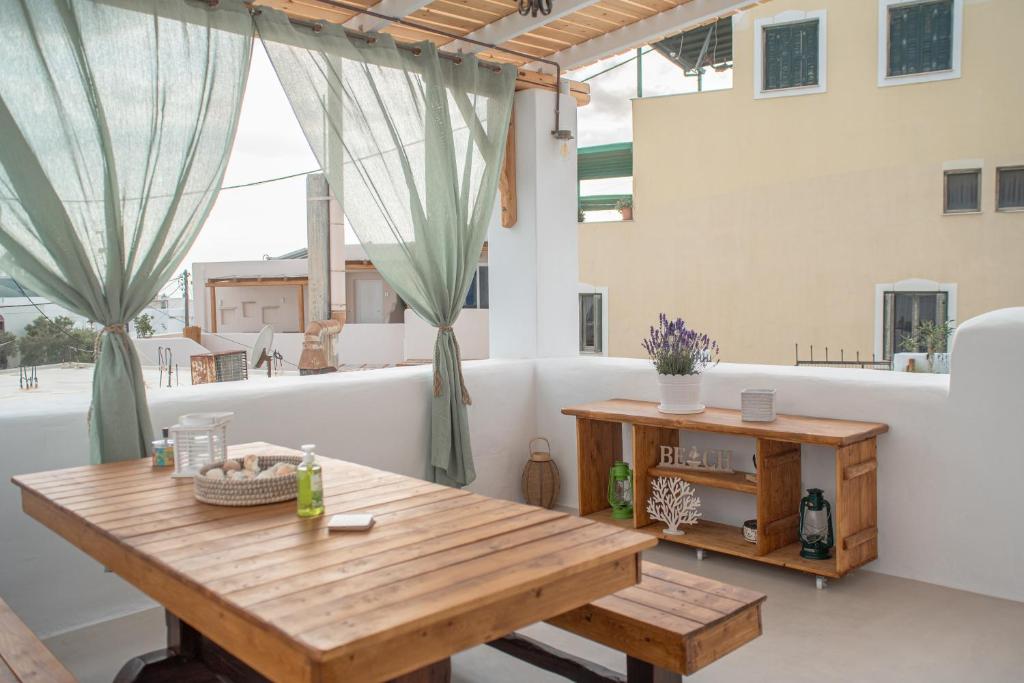 纳克索乔拉Mythical Luxury Apartment的带阳台的木桌客房