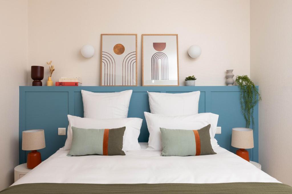 昂热Hôtel Suzane的卧室配有蓝色和白色的床和枕头
