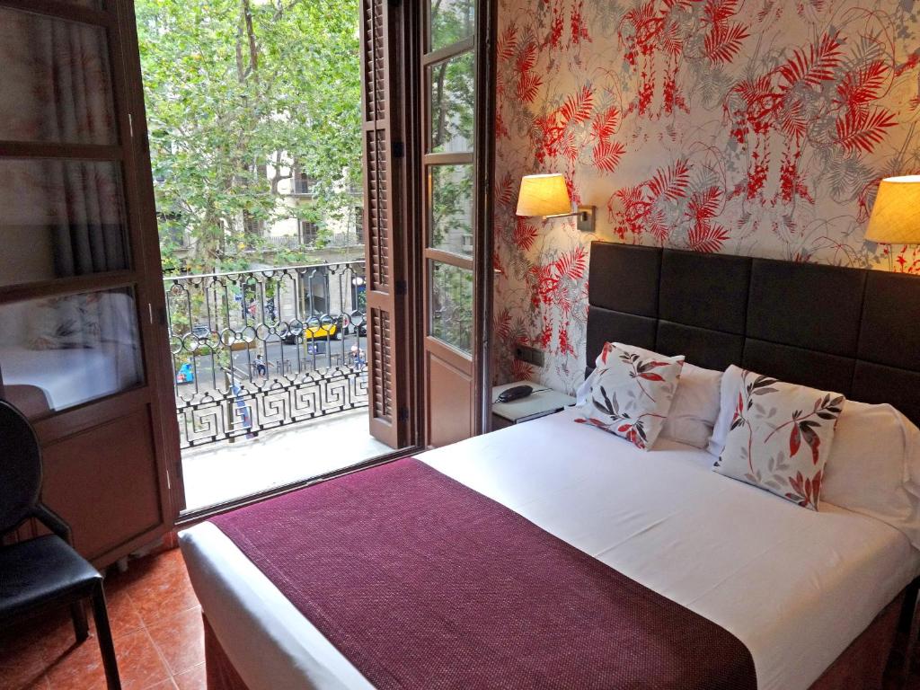 巴塞罗那略雷特兰布拉酒店的一间卧室设有一张床和一个大窗户