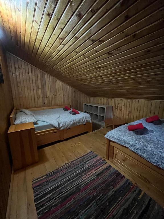 普雷代亚尔Casuta noastra din Predeal的客房设有两张床和木制天花板。