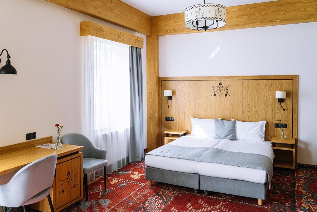 什恰夫尼察Hotel Maria & Spa的一间卧室配有一张床、一张桌子和一把椅子