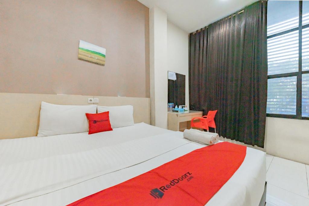 班贾尔马辛RedDoorz near Pasar Tarapung Siring Banjarmasin的一间卧室配有一张带红色毯子的大床