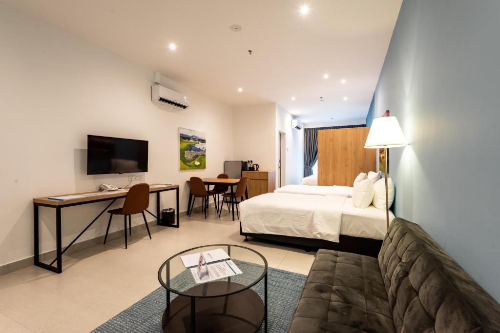 普崇The Signature Serviced Suites Puchong的配有一张床和一张书桌的酒店客房