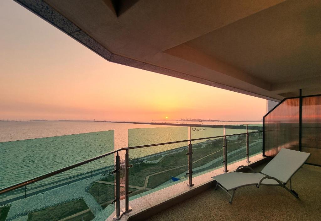 始兴市Hotel GITE的阳台配有椅子,日落时分享有海景