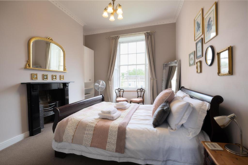 巴斯Crescent Green的一间卧室配有一张带壁炉和镜子的床
