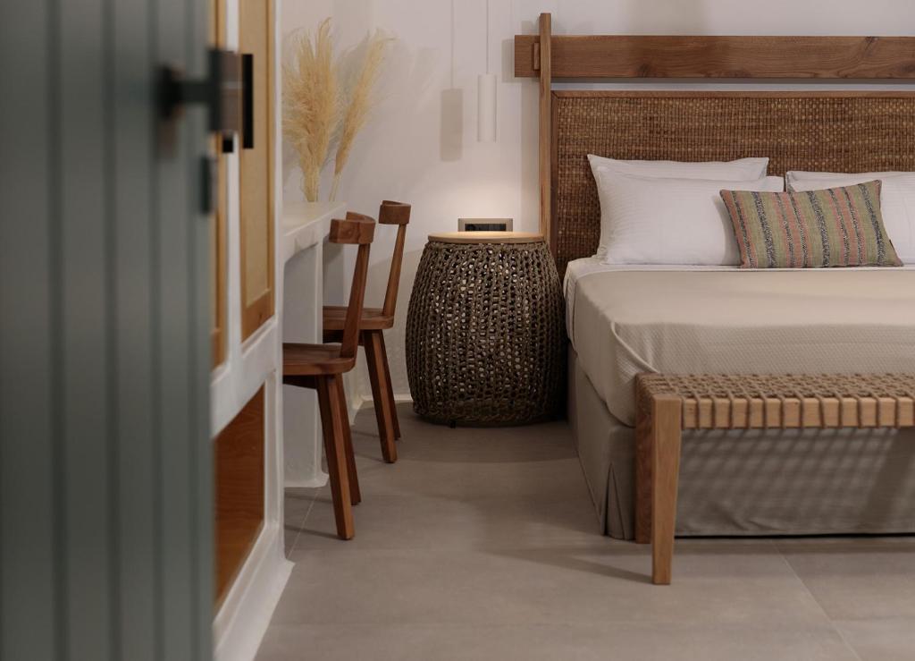 纳克索乔拉Makava Suites Naxos的卧室配有1张床、1张桌子和1把椅子