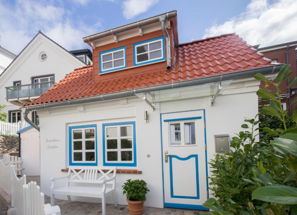 汉堡布兰肯内泽鲁特胡斯公寓的小屋设有红色屋顶和蓝色门