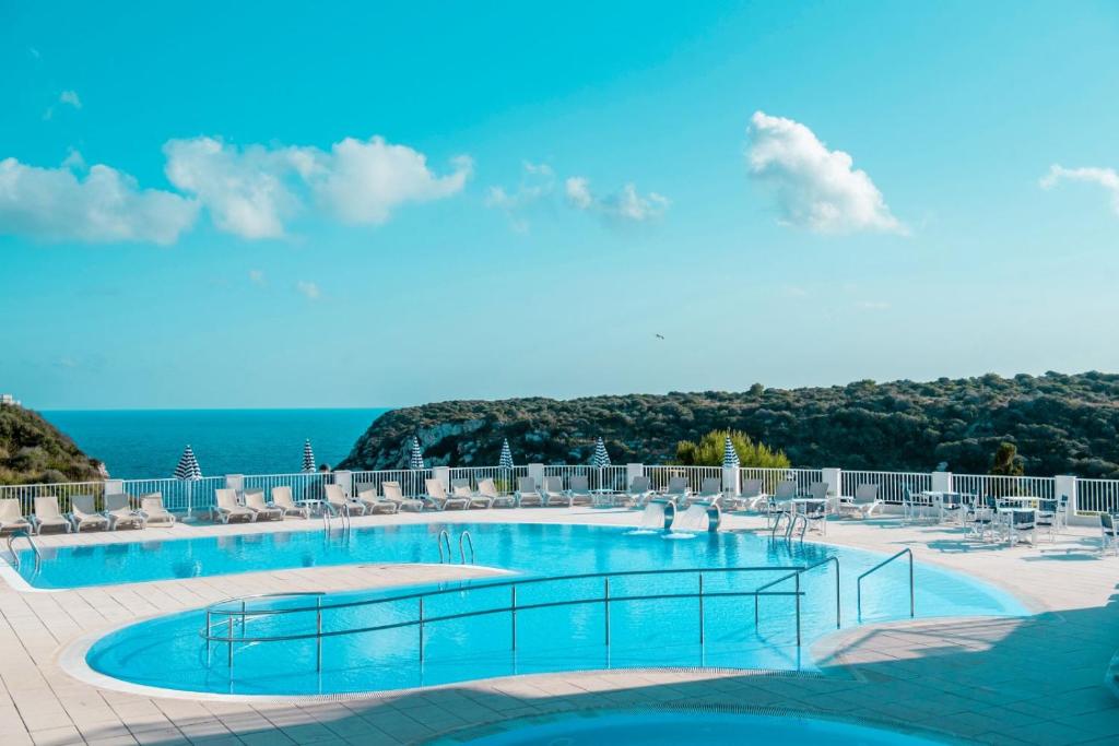 卡拉恩波特Seth Playa Azul的一个带椅子的游泳池,背景是大海