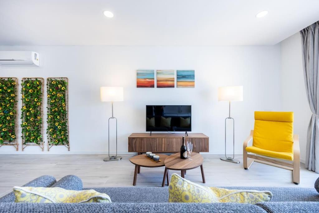 布尔高The Hub central apartment Burgau的客厅配有蓝色的沙发和黄色的椅子