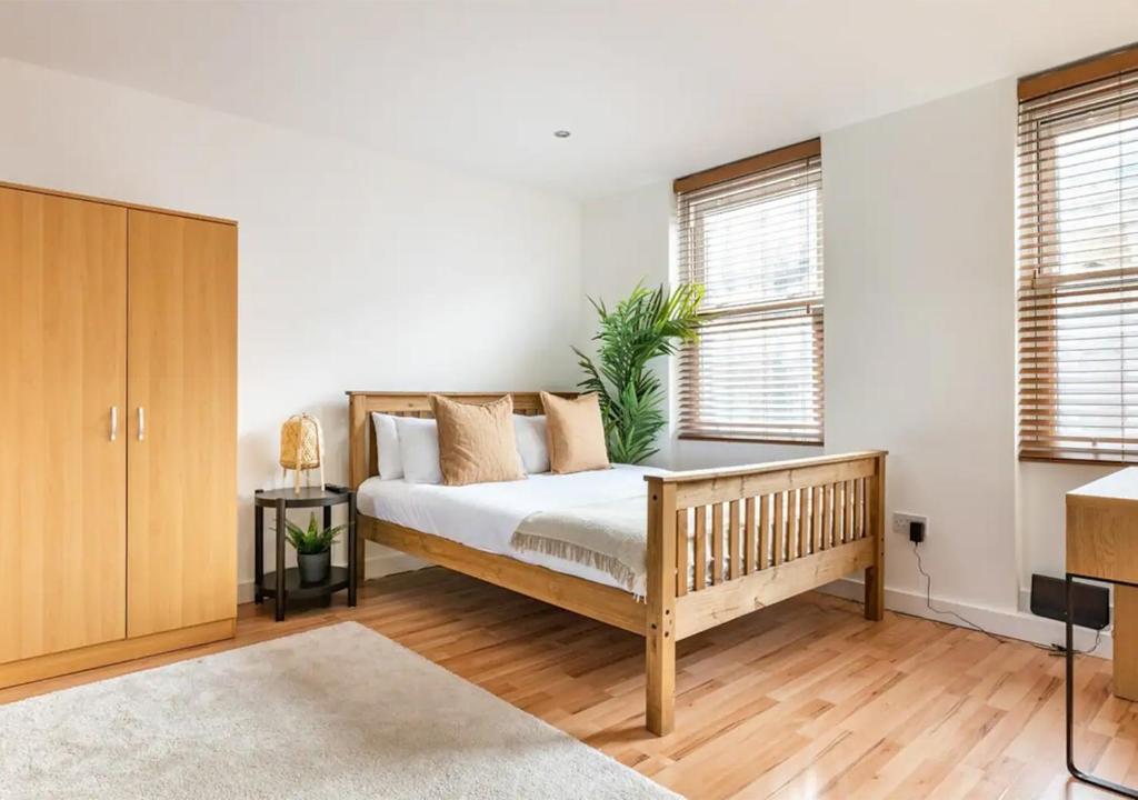 伦敦Modern Studio Apartment In Shoreditch的一间卧室设有一张床和两个窗户。
