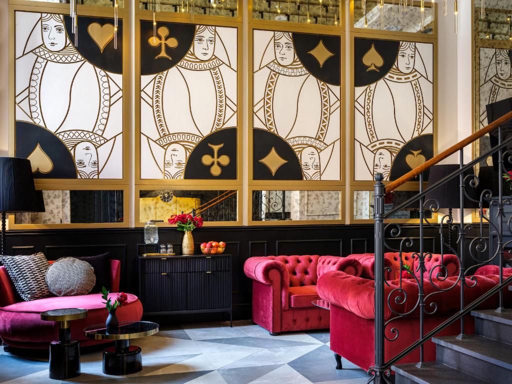 克拉科夫Golden Queen Aparthotel的大堂设有红色的沙发和彩色玻璃窗
