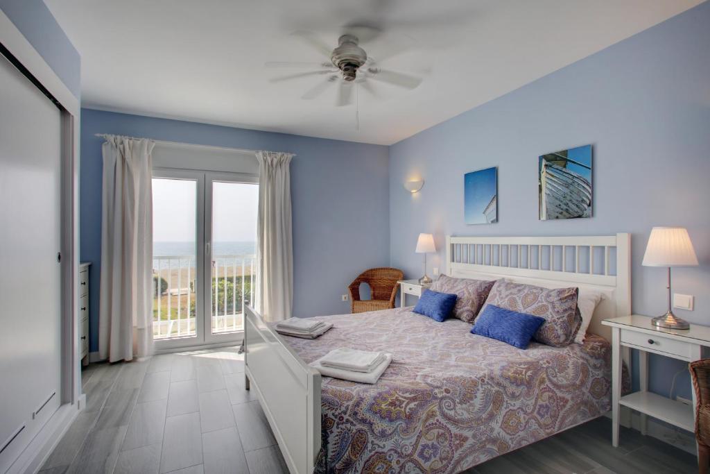 卡萨雷斯阁下海滩休闲度假公寓的一间卧室设有一张床和一个阳台
