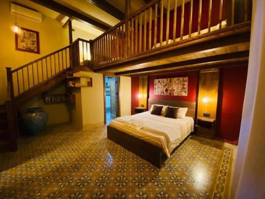 艾因西莱姆Ta' Ciangura House of Character的一间带大床和楼梯的卧室