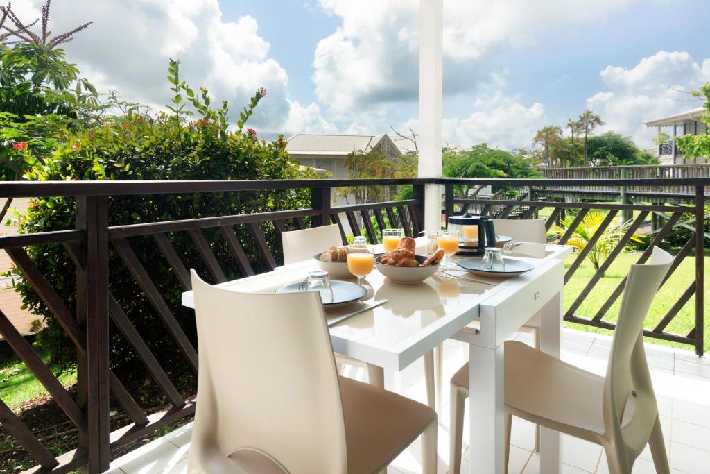 圣弗朗索瓦Tropical Cocooning的阳台上配有白色的桌椅