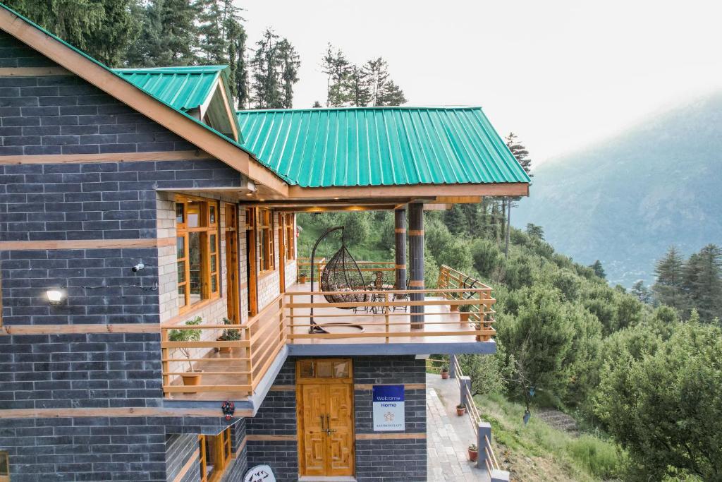 马拉里SaffronStays Kesar Villa, Manali - beautiful villa amidst an apple orchard - All clear roads的山边的绿色屋顶房子