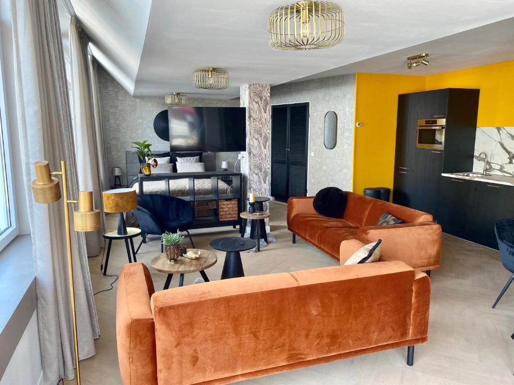 海边的艾格蒙特Glücklich am Meer Suite Deluxe mit Wellnesszugang的客厅配有橙色家具和黄色墙壁