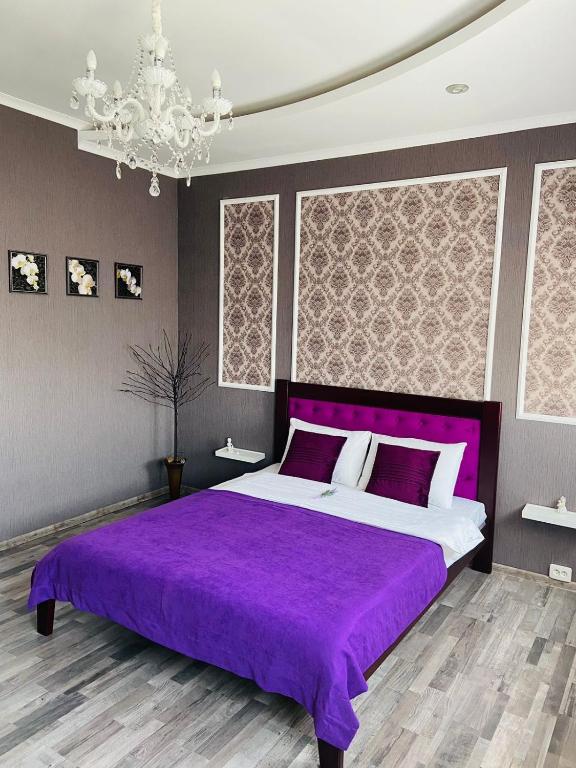 丰坦卡Готель Лаванда на Ривьере , Карпатский чан, Фонтанка 1 Одесса的一间卧室配有紫色的床和吊灯。