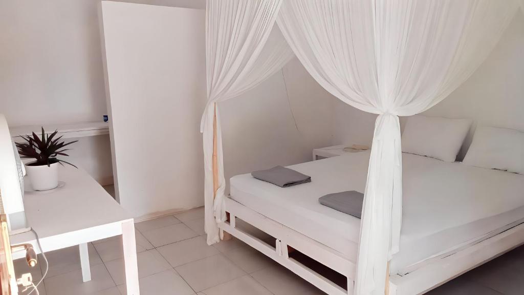 Ruathe village rua beach homestay的白色卧室配有一张带天蓬的床