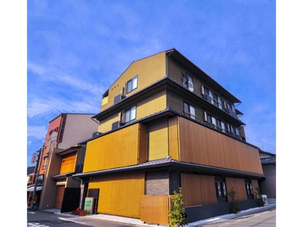 京都HIZ HOTEL Kyoto Nijo Castle - Vacation STAY 12537v的街上的黄色和棕色建筑