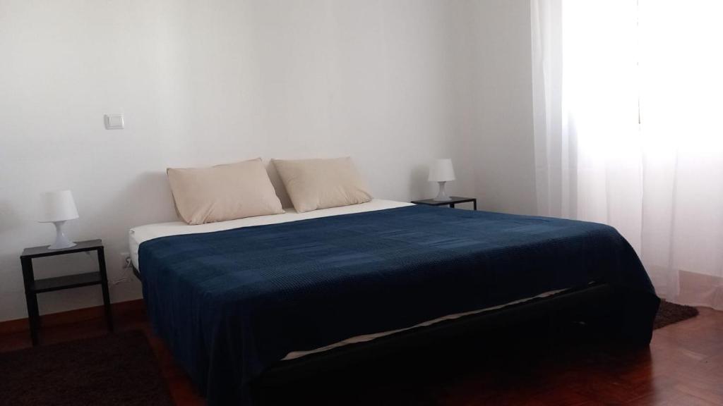 阿尔布费拉Anchor House的一间卧室配有一张带蓝色毯子的床