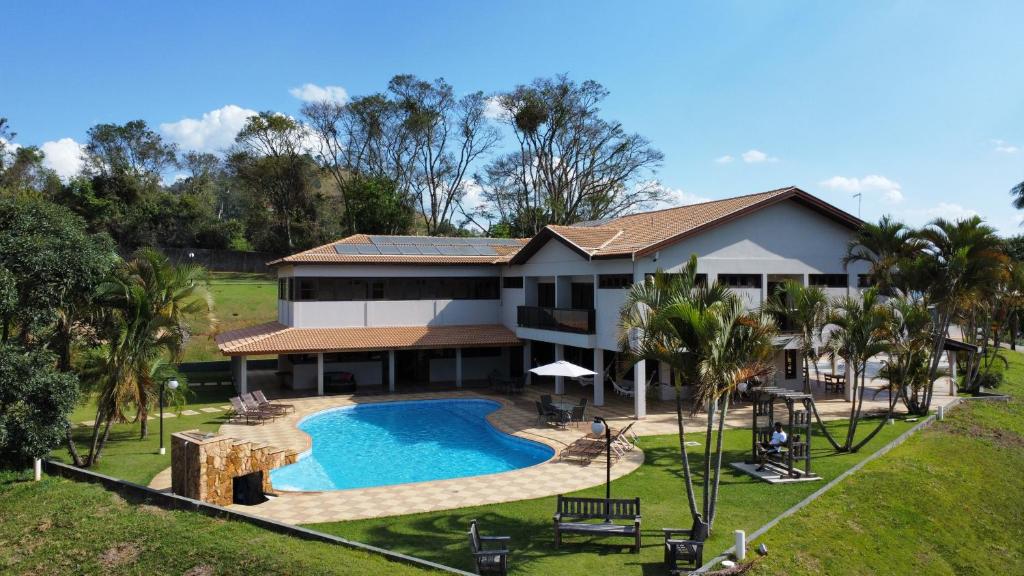 阿瓜斯迪林多亚Pousada Costa Rielli的享有带游泳池的房屋的空中景致