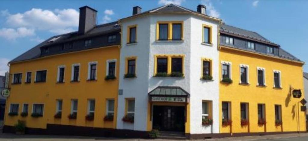 Thum祖尔林德酒店的黑色屋顶的黄色和白色大建筑