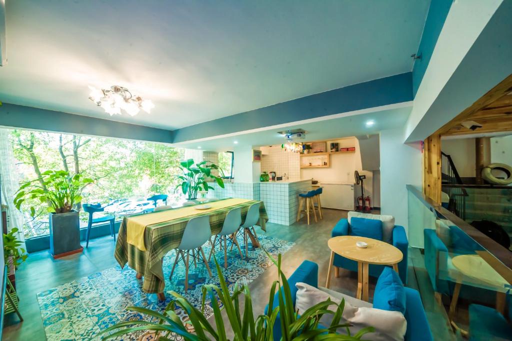 张家界Yixun Inn的客厅配有桌子和蓝色椅子