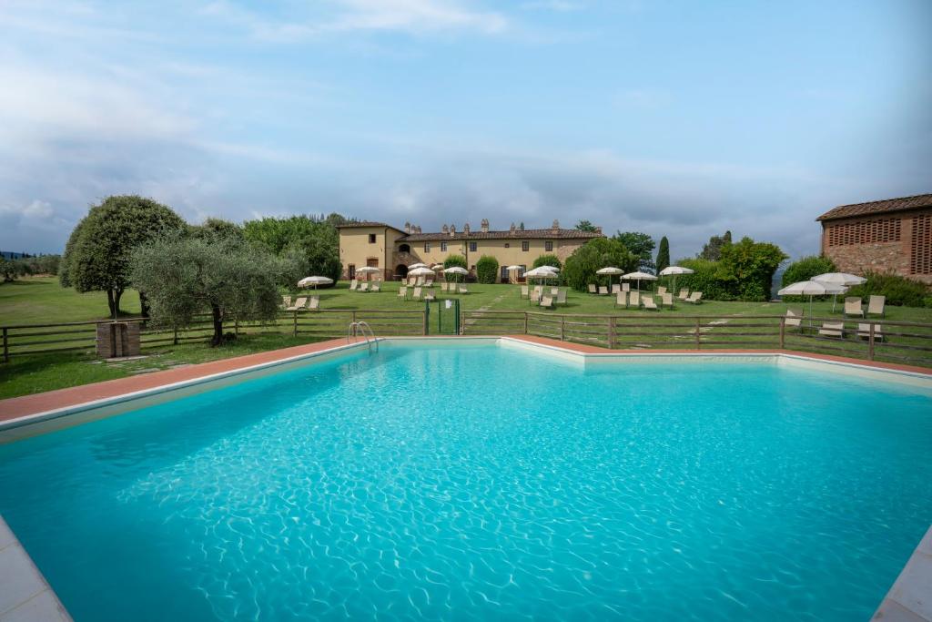 圣吉米纳诺Fattorie Santo Pietro的一座大蓝色游泳池,位于房子前