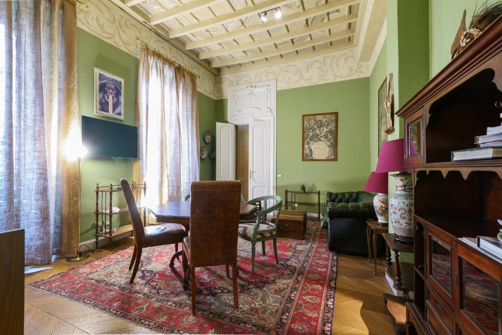 米兰Prestige Boutique Aparthotel - Montenapoleone的客厅设有绿色的墙壁和桌椅