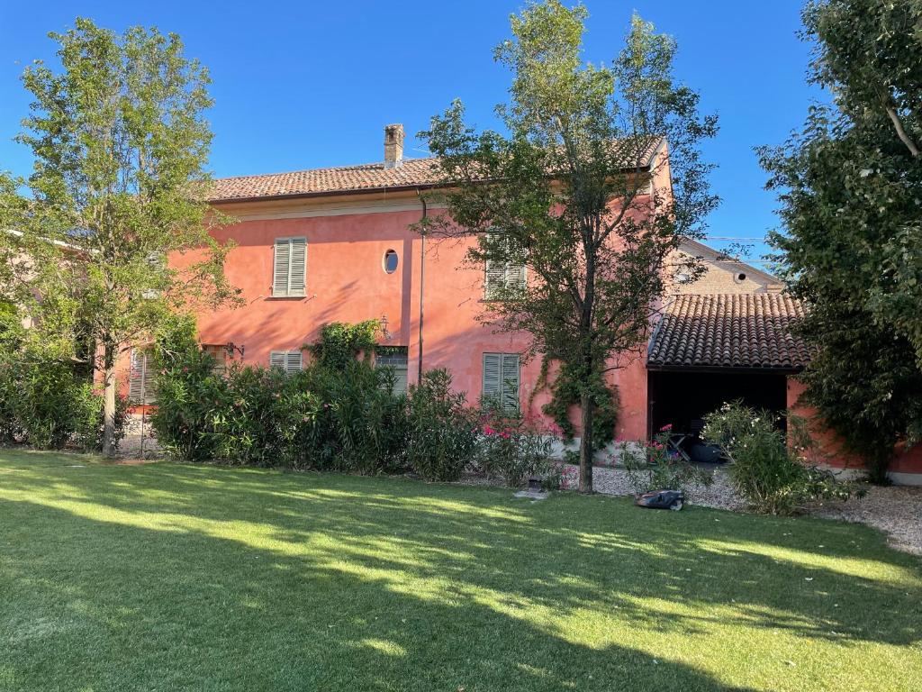 托尔托纳Country House La Viscarda的一座带草地庭院的大型红色房屋