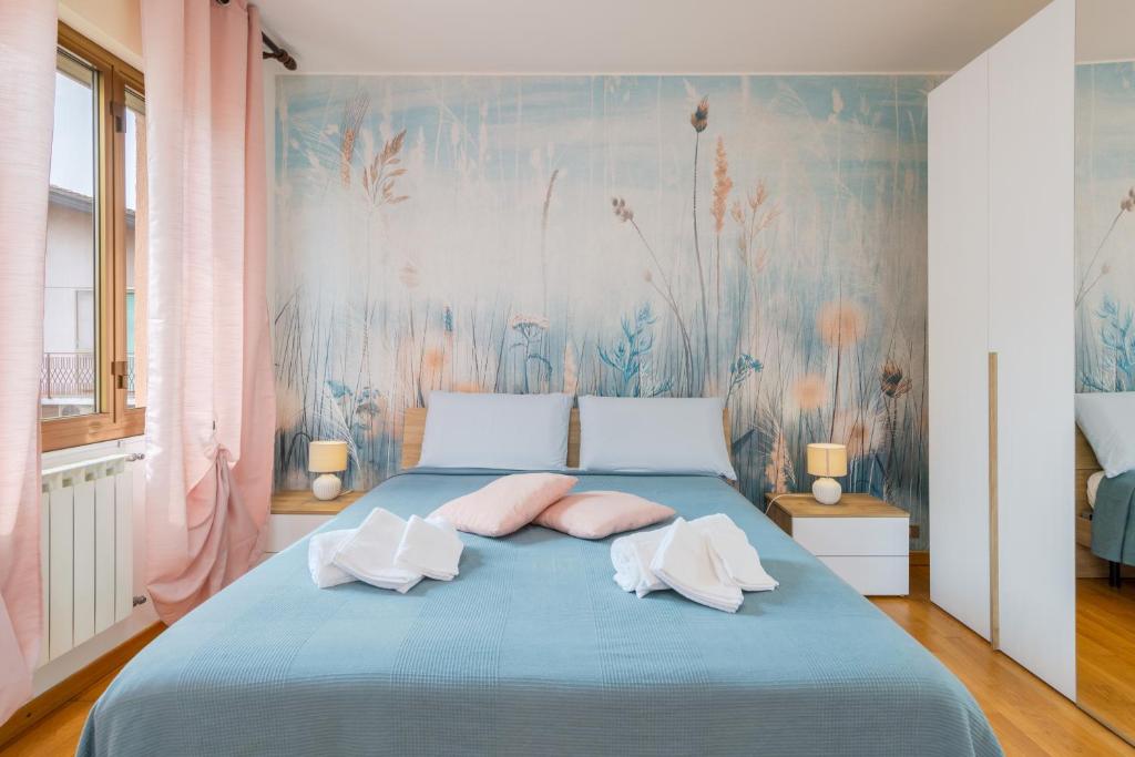 泰塞拉MarcoPoloAirport-3 Camere da letto-Wifi-Netflix-15' da Venezia的一间卧室配有蓝色的床和粉红色枕头