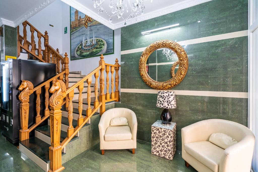 瓦伦西亚Hostal RR Feria by Beleret的客厅设有楼梯、2把椅子和镜子