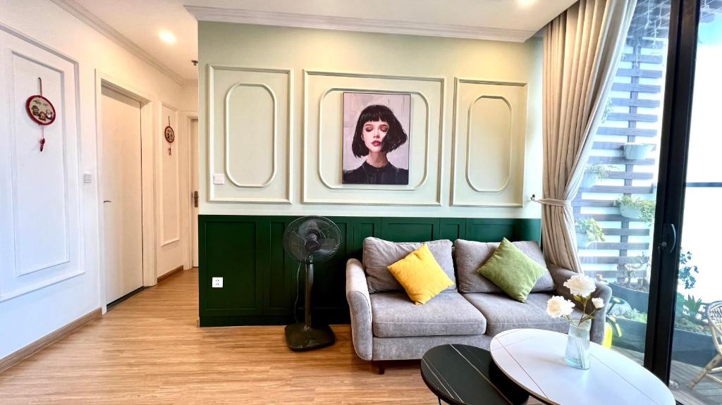 河内NanaHousing-Vinhomes Skylake-Luxury Apartment near Keangnam的客厅配有沙发和墙上的照片