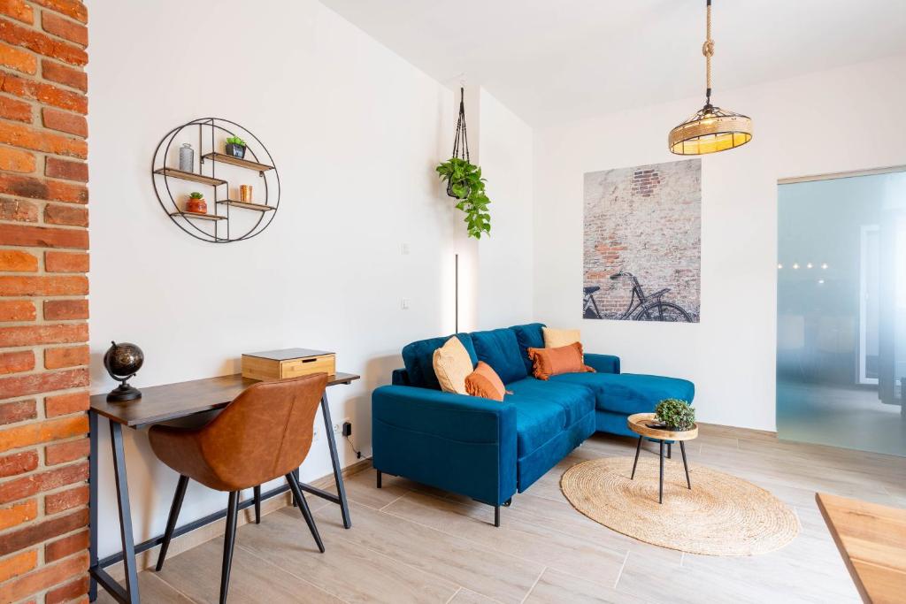 茨维考FeelgooD Apartments DELUXE Zwickau CityCenter mit TG-Stellplatz, Netflix und Waipu-TV的客厅配有蓝色的沙发和桌子