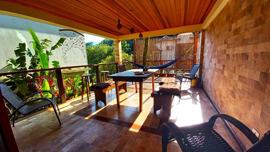 阿布拉奥Casa Iluminalia的阳台配有吊床和桌椅。