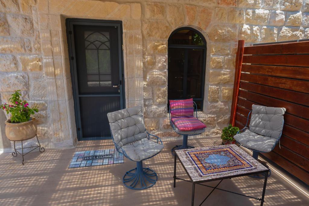 耶路撒冷פרלה צימרים的门廊配有两把椅子和一张桌子,门