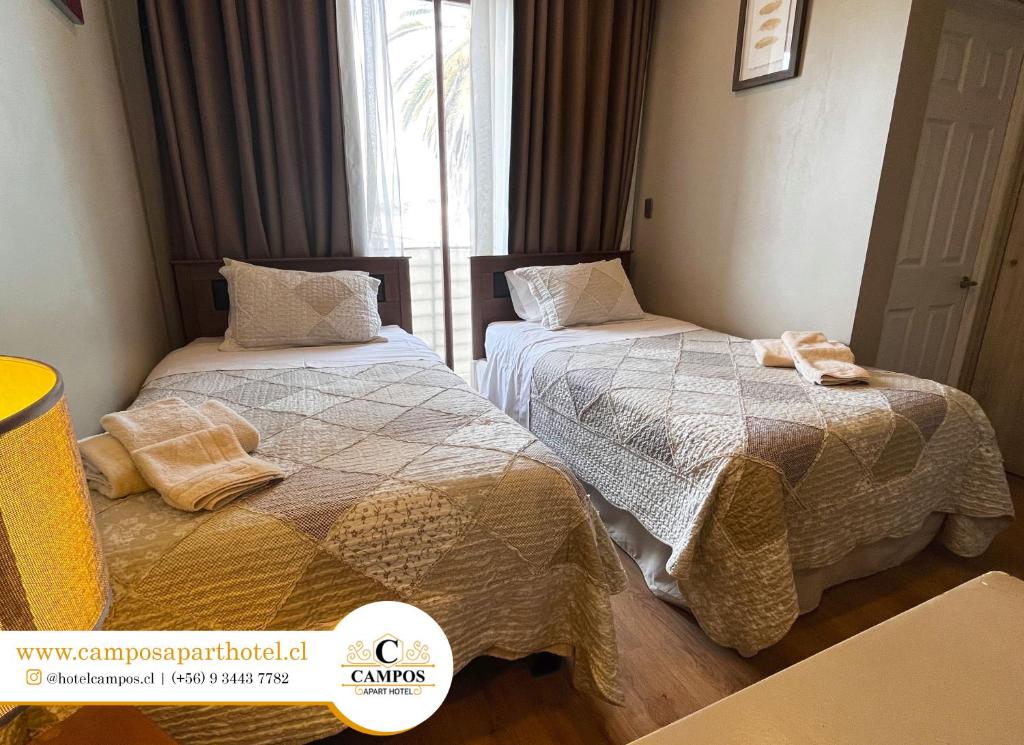 兰卡瓜Apart Hotel Campos Rancagua的一间卧室设有两张床和窗户。