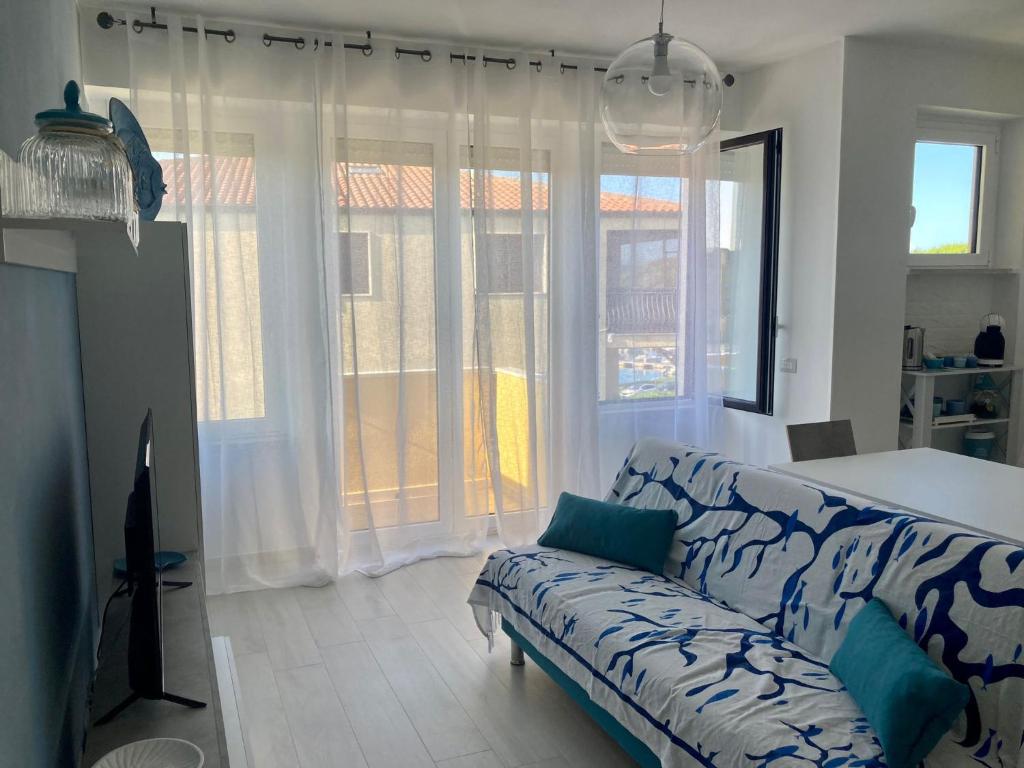 马达莱纳Appartamento Tizzy的带沙发的客厅和部分窗户。