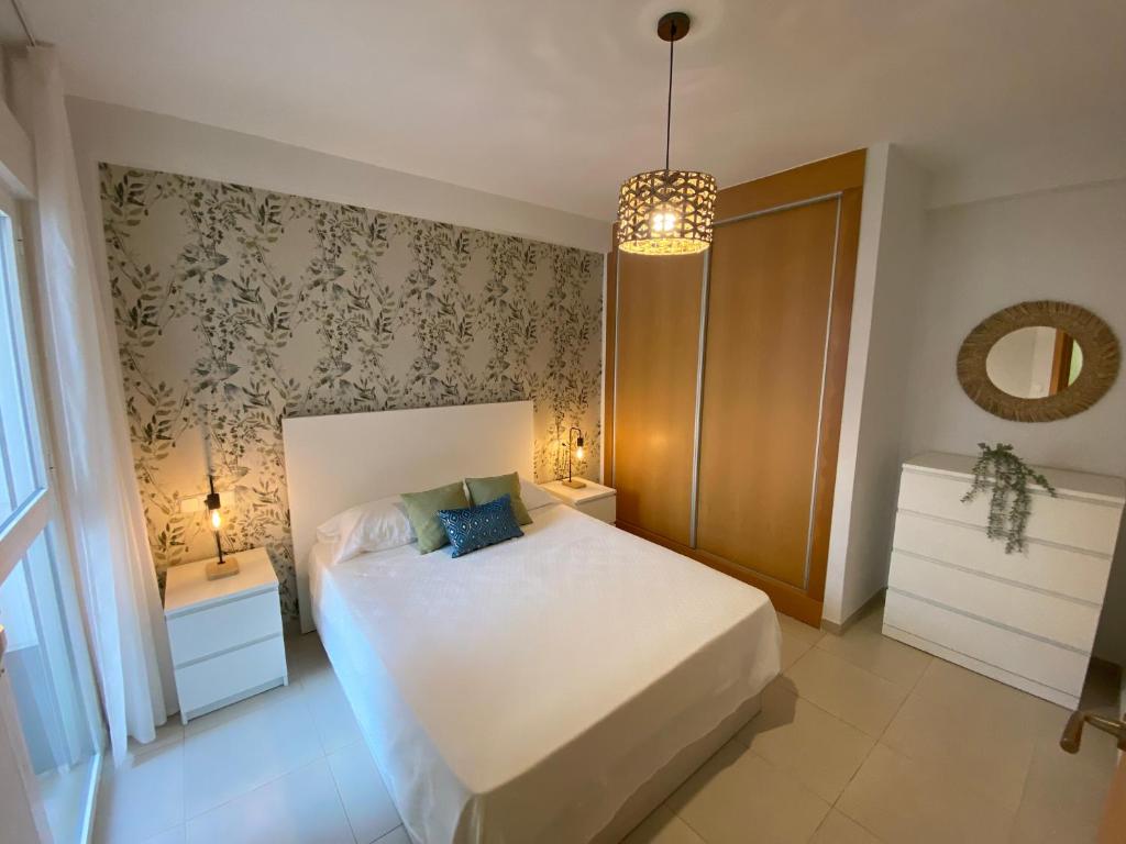 维拉Lagunas Home, bajo con terraza al lado de la playa的卧室配有白色的床和2个床头柜